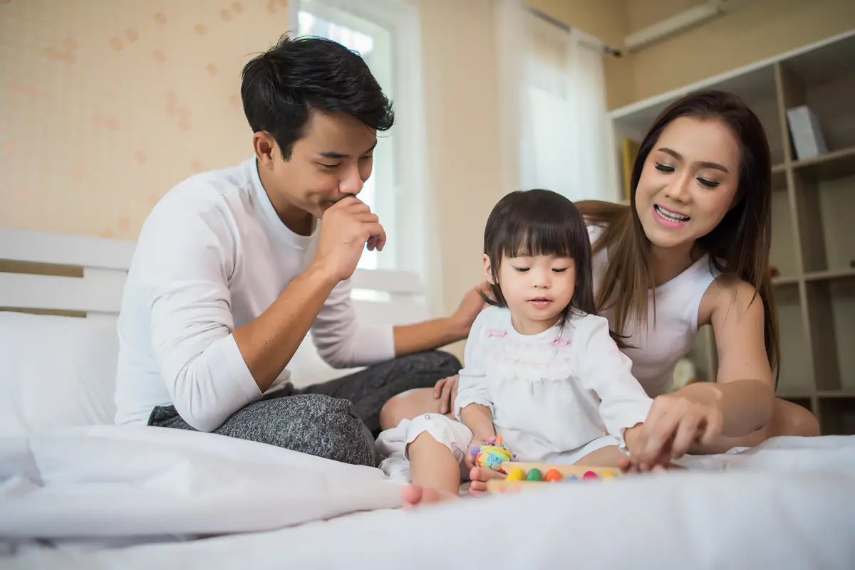 rsz_happy-child-with-parents-playing-bed-home image