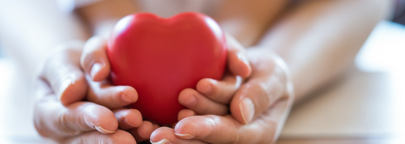 Hands holding a red heart representing heart care and cardiology services